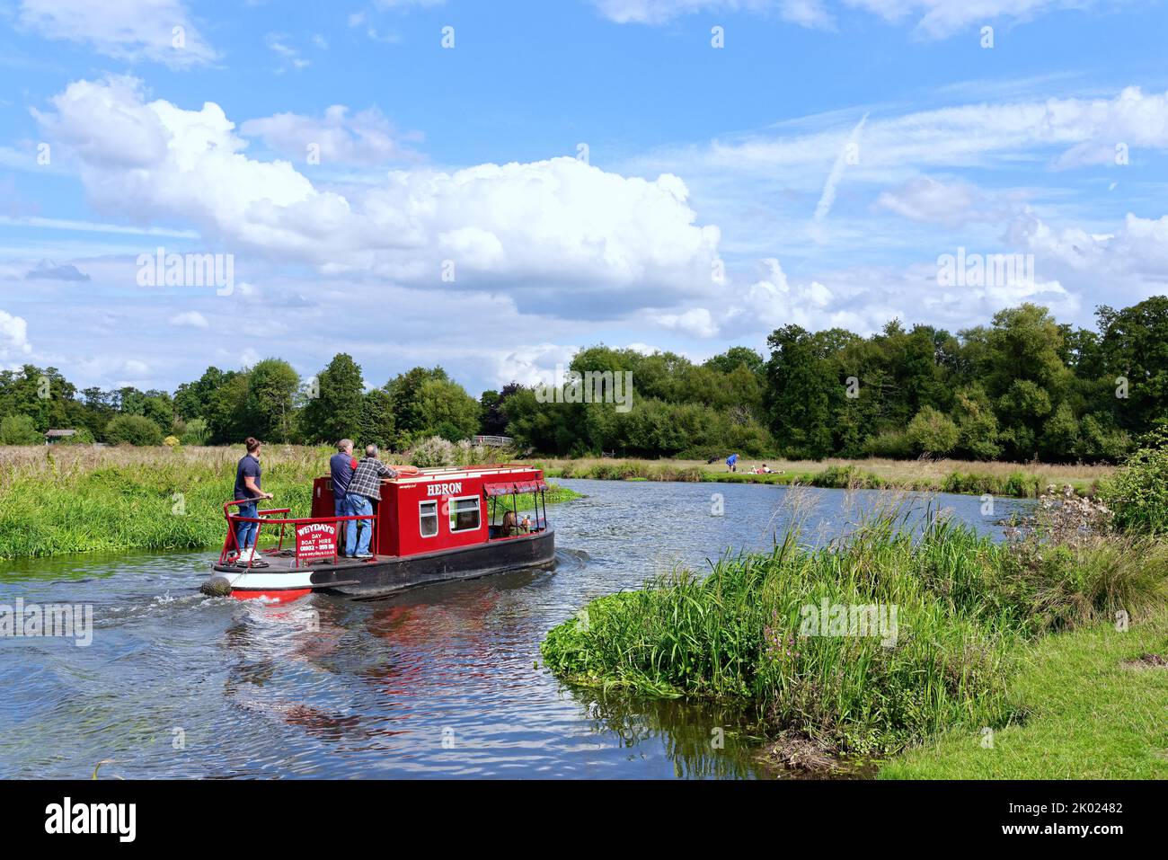 A lone narrow boat cruising on the River Wey navigation canal near Ripley on a summers day Surrey England UK Stock Photo