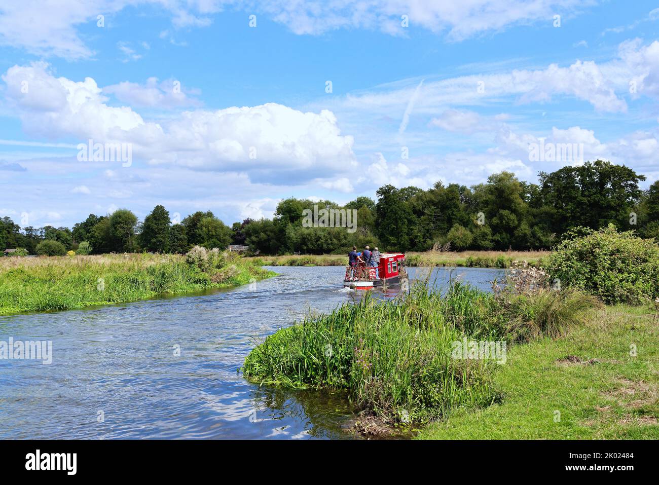 A lone narrow boat cruising on the River Wey navigation canal near Ripley on a summers day Surrey England UK Stock Photo