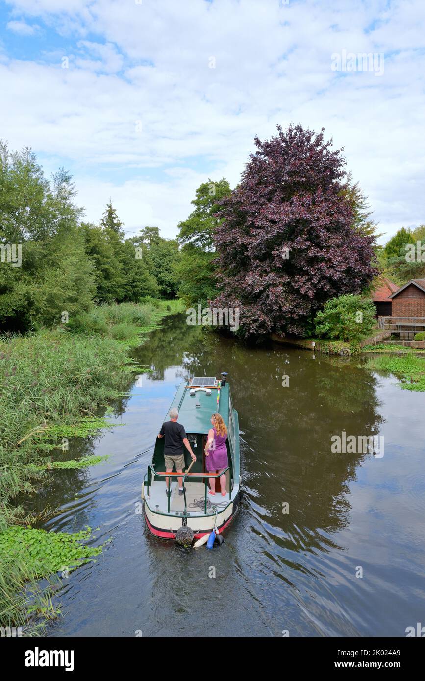 An elevated view of a small narrow boat cruising along the River Wey navigation Canal near Ripley on a summers day Surrey England UK Stock Photo