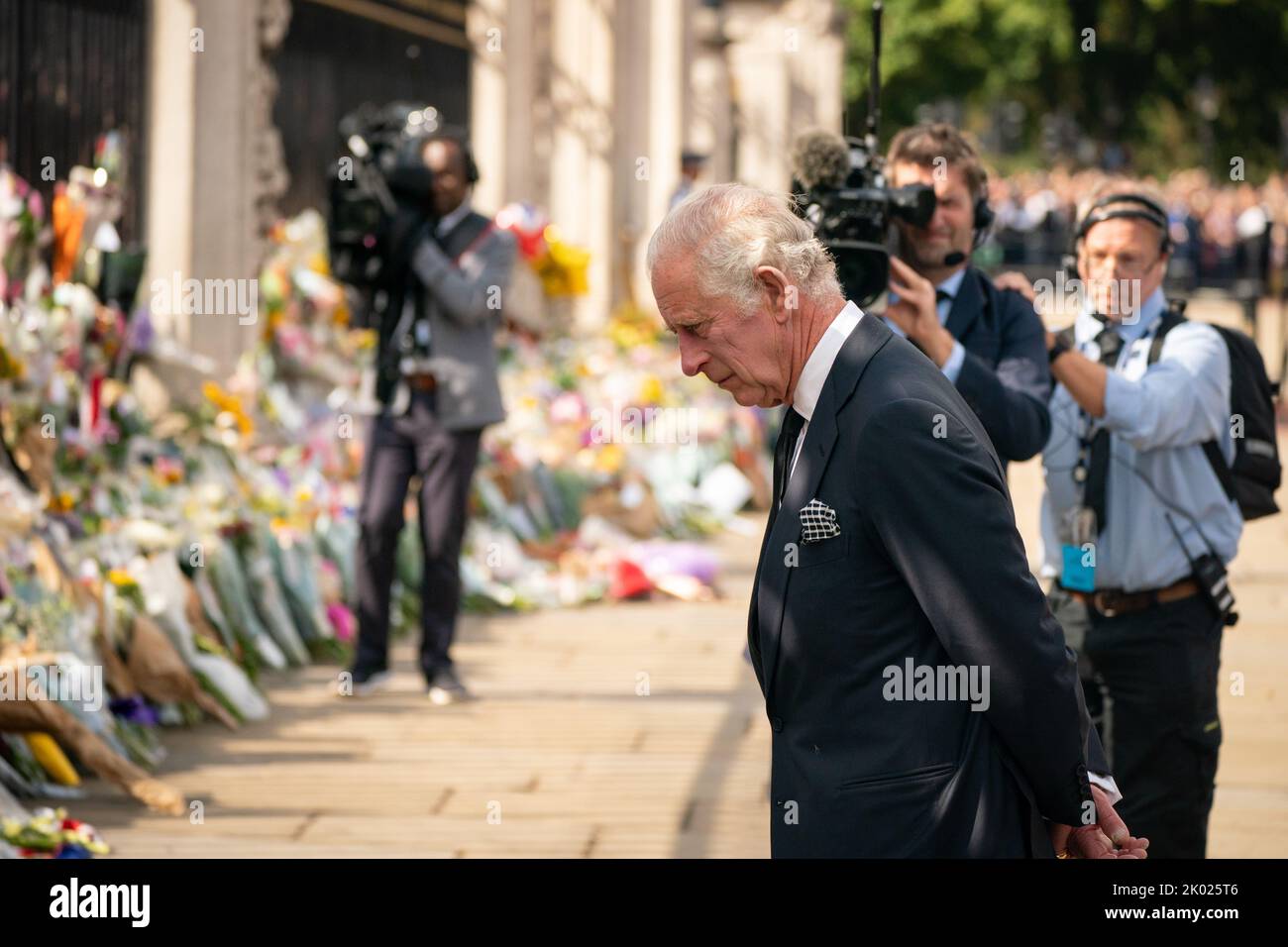 King Charles III looks at flowers outside Buckingham Palace, London after travelling from Balmoral following the death of Queen Elizabeth II on Thursday. Picture date: Friday September 9, 2022. Stock Photo