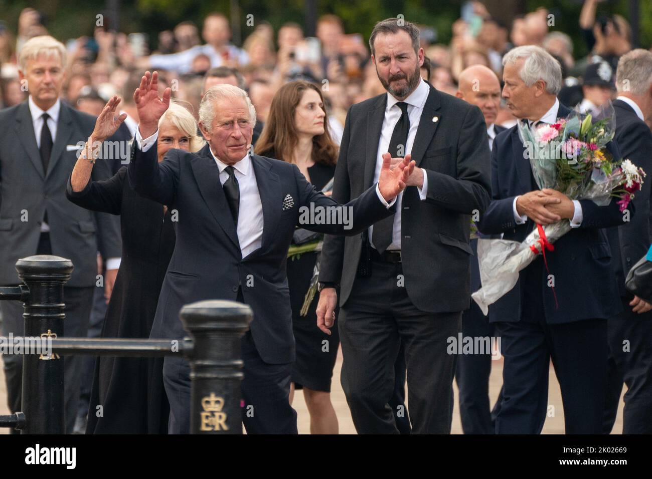 King Charles III and the Queen wave to the crowd outside Buckingham