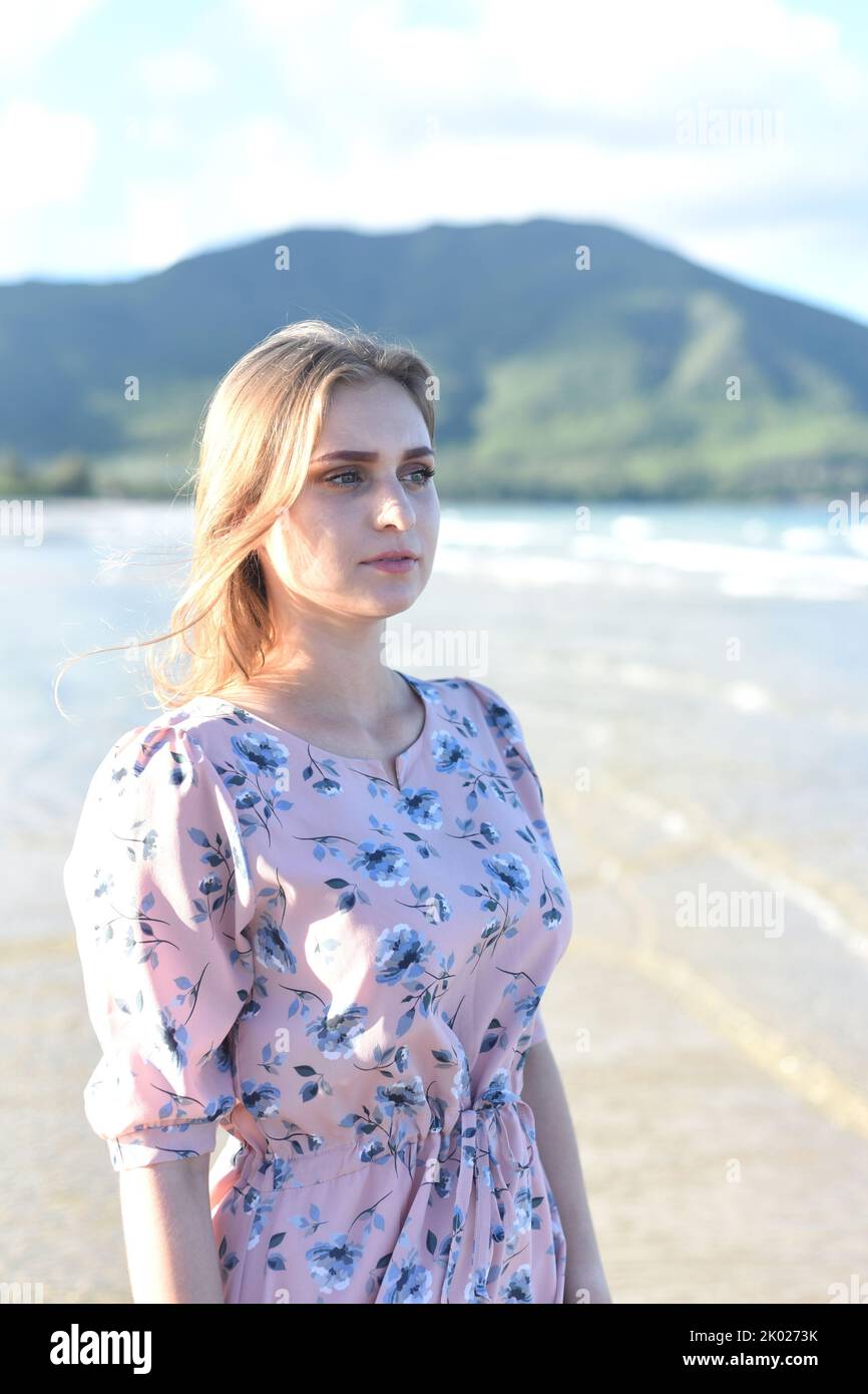 Beautiful Belarus woman walking on the beach against dramatic and romantic sky Stock Photo