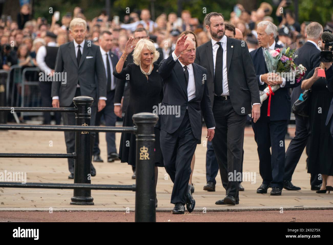 King Charles III and the Queen wave to the crowd outside Buckingham