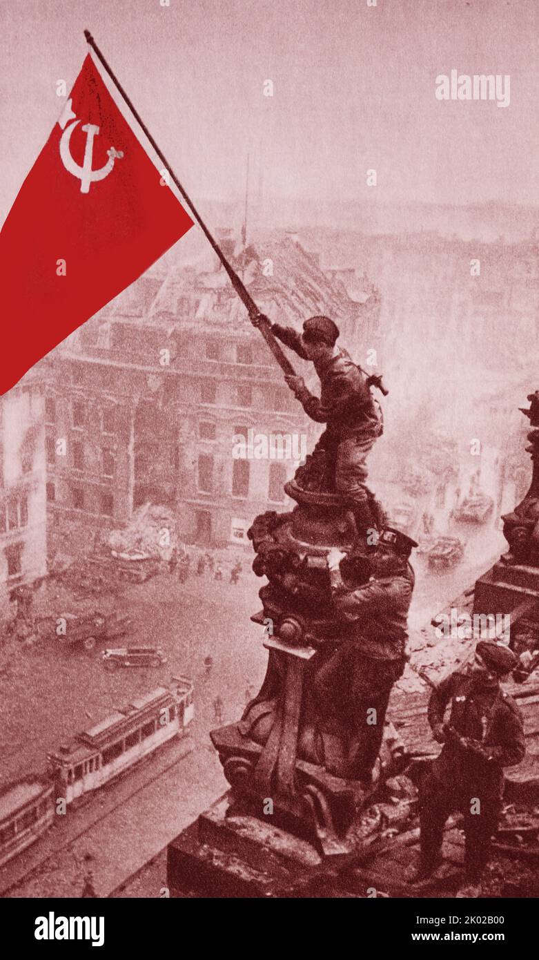 *Colorized* On April 30, 1945, the scarlet banner of Victory was hoisted over the burning Reichstag in Berlin. On May 8, the act of unconditional surrender of fascist Germany was signed. The Soviet army saved the peoples of Europe from fascist slavery. Stock Photo