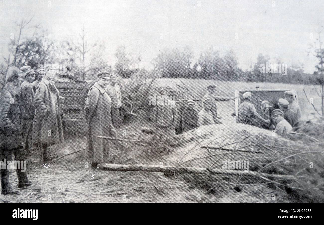 Western Front Political Departments Chief A.F. Myasnikov (x) at the combat positions of the unknown artillery unit at the Western front. To your left is a chief of the Western front publishing department - A.B.Kadyshev (xx). 1920. Photo Stock Photo