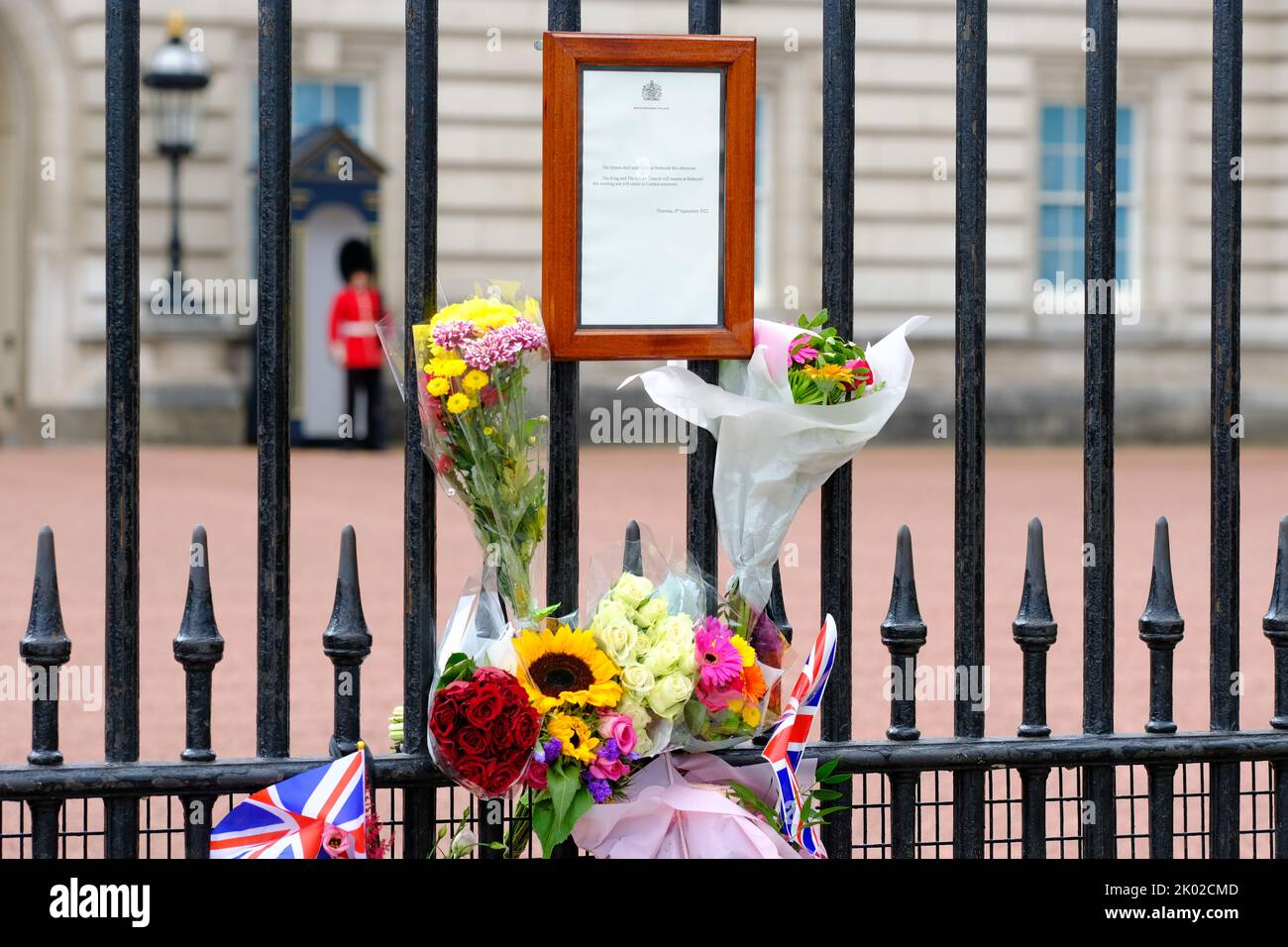 Buckingham Palace, London, UK – Friday 9th September 2022 – Flowers and flags now surround the official death notice of Queen Elizabeth II outside Buckingham Palace. Photo Steven May / Alamy Live News Stock Photo