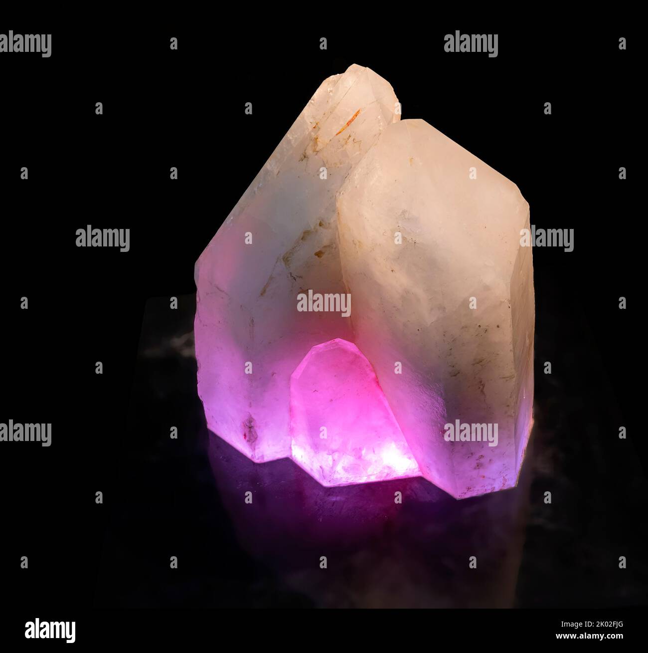 rock crystal shine through by lilac light on black ground Stock Photo