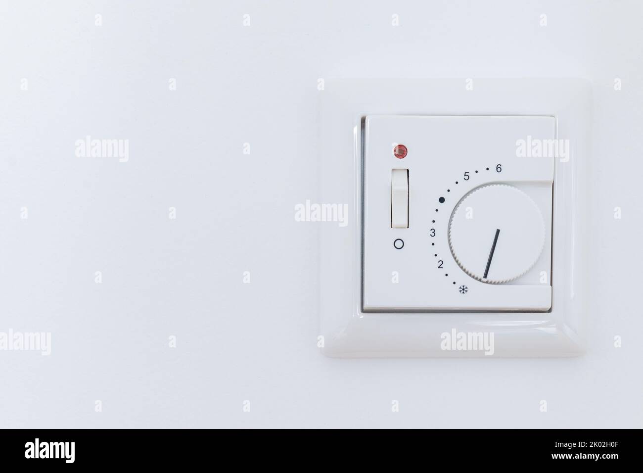 Thermostat heating switch on wall Stock Photo