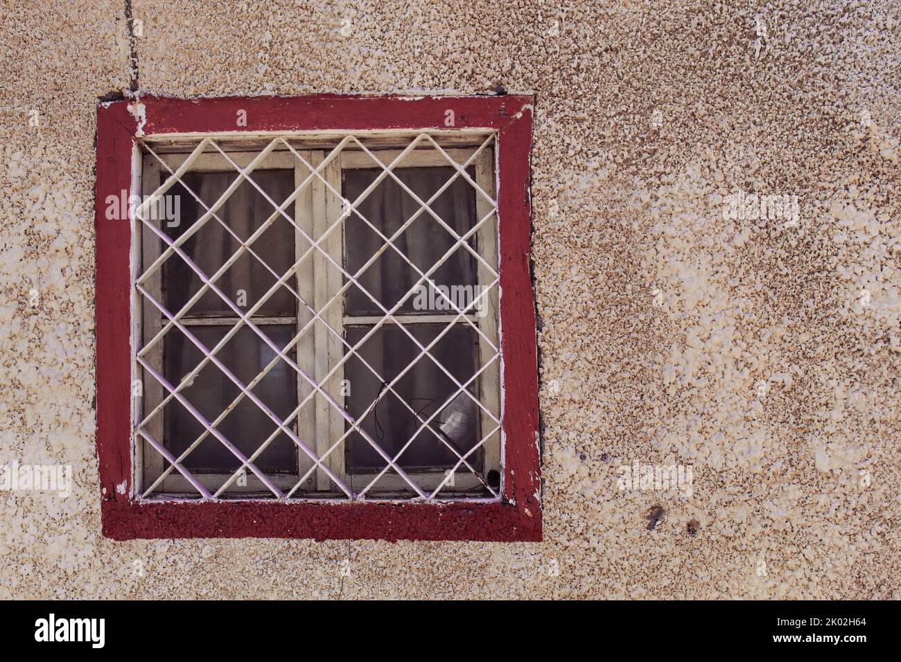 A white window, red painted frame and dirty wall, selective focus Stock Photo