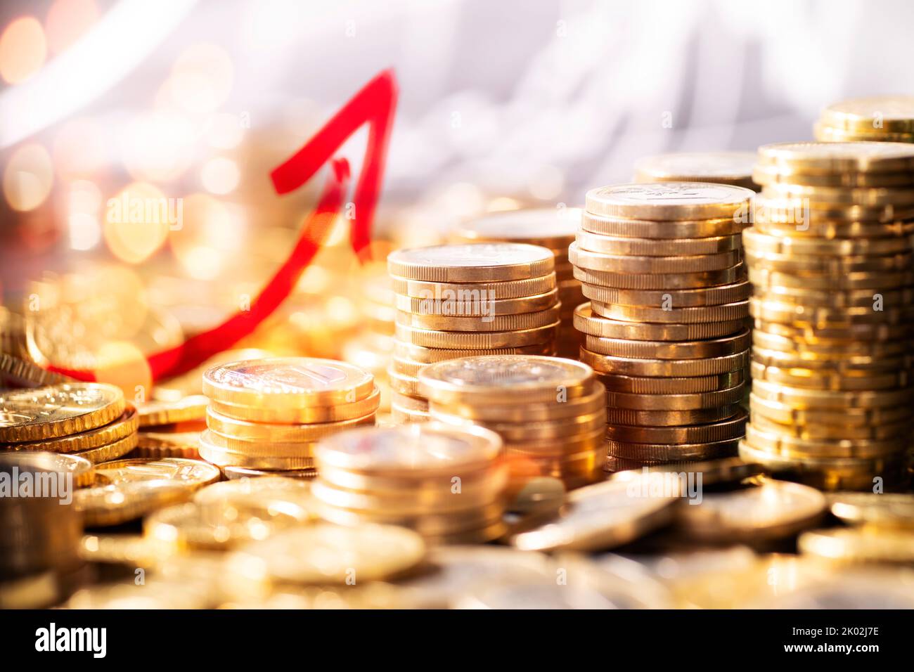 Stack of coins in front of an upward curve symbolizing a growth of wealth Stock Photo