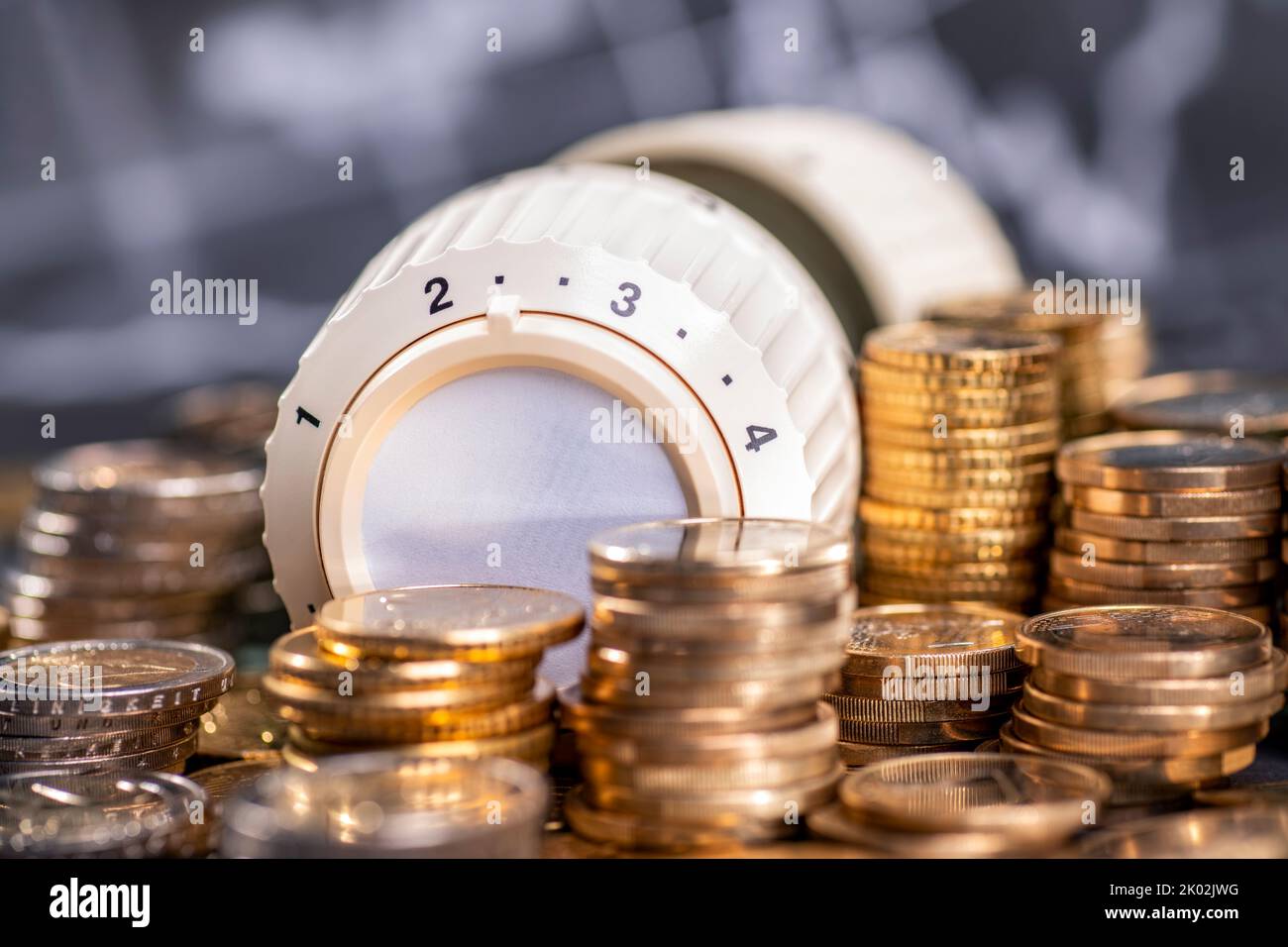 High cost of heating. Thermostat of a heater with stacks of money. Stock Photo