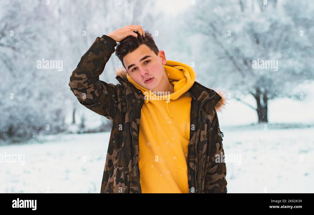 Portrait of young man in snowy winter forest. Season, christmas Stock Photo