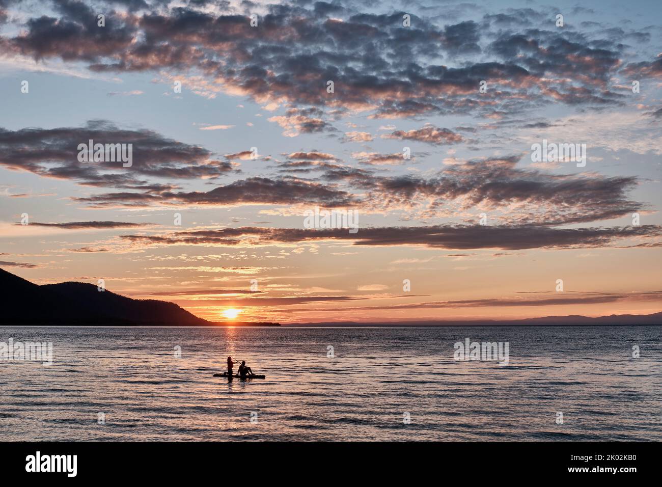 Barguzinsky Bay of Lake Baikal, Russia. Colorful sunset. Silhouette of