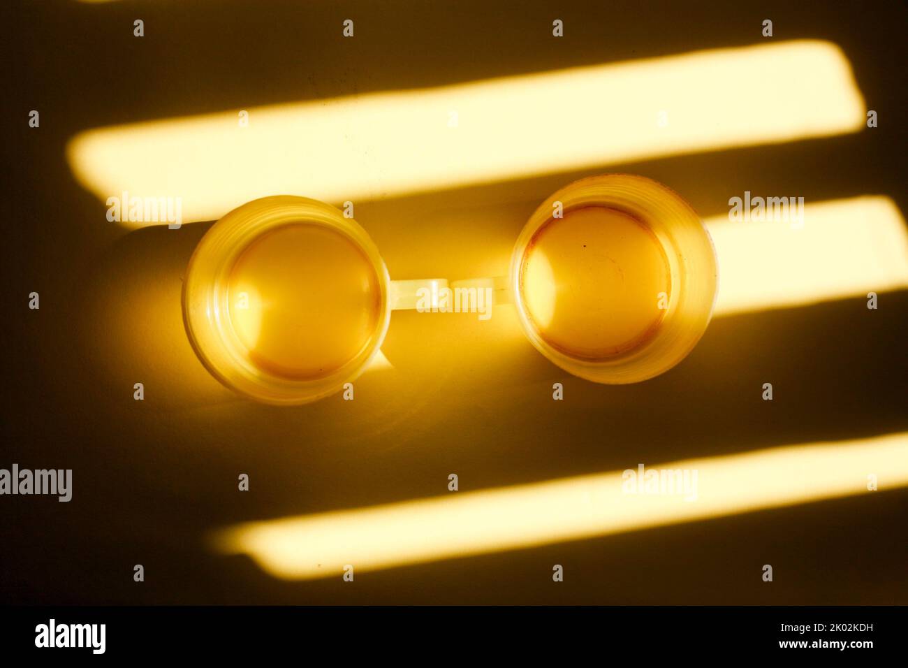 yellow plastic cup isolated on light and shadow Stock Photo