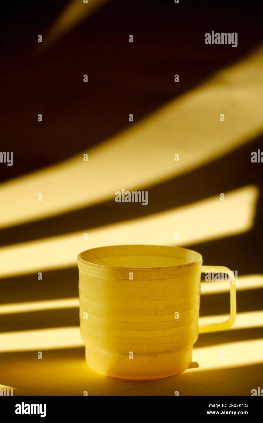 yellow plastic cup isolated on light and shadow Stock Photo