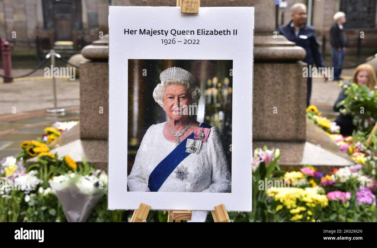 Manchester, UK, 9th September, 2022. A photo of Her Majesty, Queen Elizabeth II, with flowers left in St Ann's Square, Manchester, UK. Mourning period begins after the death of Her Majesty, Queen Elizabeth II, in Manchester, United Kingdom.  Manchester City Council has said on its website that the city of Manchester will be observing the official 10-day mourning period and that: 'Residents may wish to lay flowers to mark Her Majesty’s death. You can lay flowers at St Ann's Square'. Credit: Terry Waller/Alamy Live News Stock Photo
