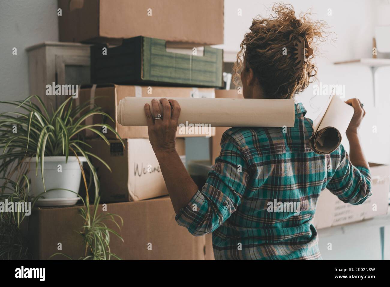 Back view of woman in front of many carton box after a moving mortgage loan. New home and life.. Female independent people enjoy flat apartment leisure. Relocation and renting concept. Indoor house Stock Photo