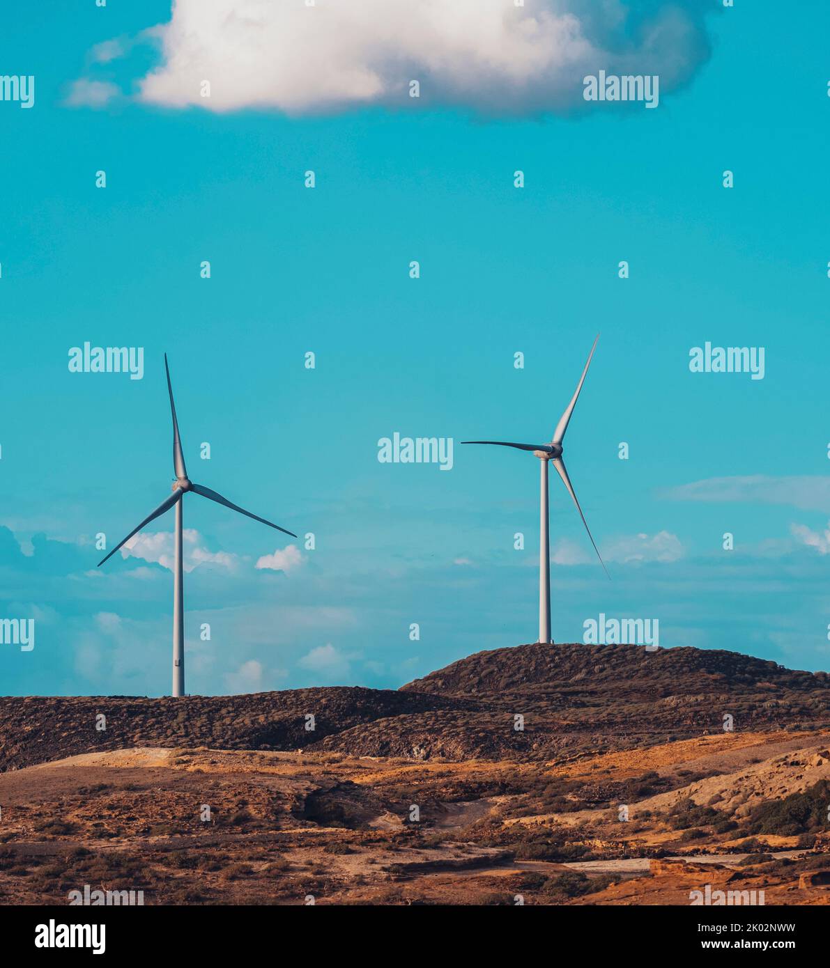 Wind turbines in the country side against a blue sky with clouds ...