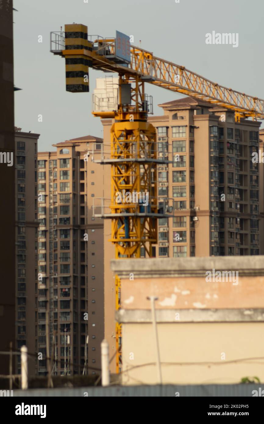 A vertical shot of a construction crane between buildings Stock Photo ...
