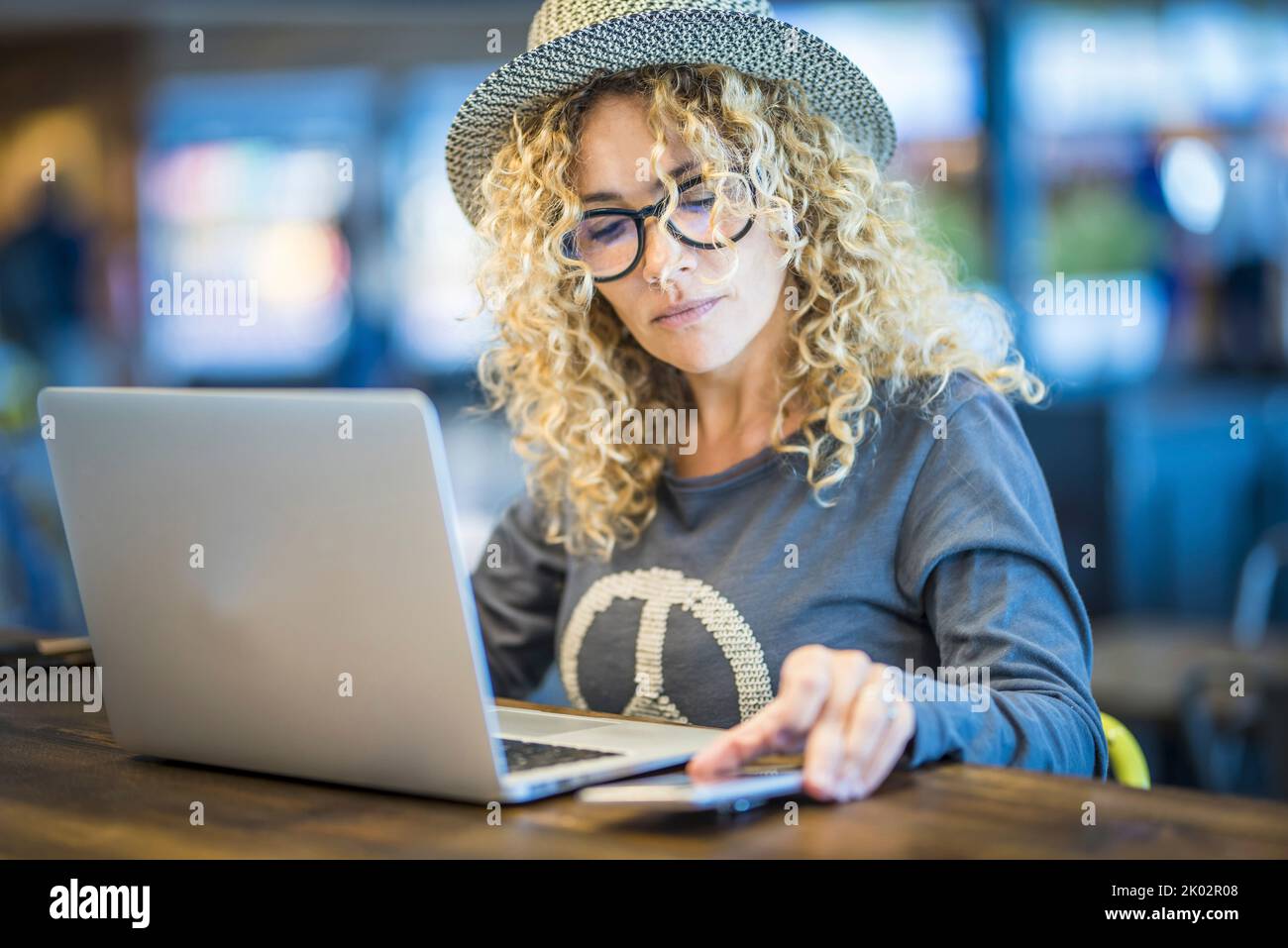 Young adult modern woman work at the store table with laptop computer
