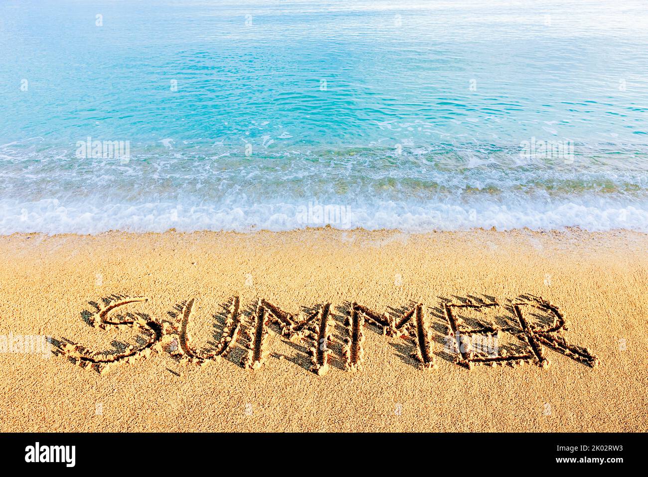 The word 'summer' written in the sand Stock Photo