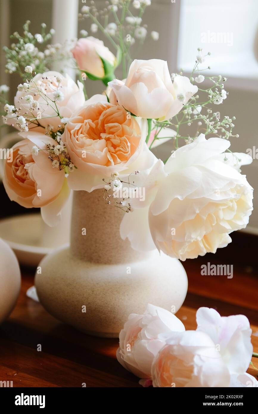 A vertical shot of orange English roses in a vase Stock Photo - Alamy