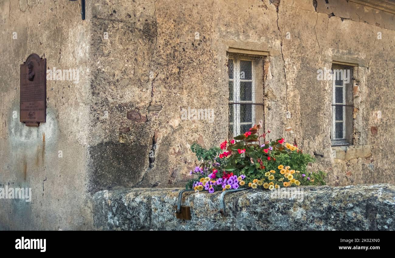Flowers on bridge railings over the Canal du Midi in Le Somail. The Canal is a UNESCO World Heritage Site and was completed in 1681. It was designed by Pierre Paul Riquet. The stone bridge is classified as a Monument historique. Stock Photo