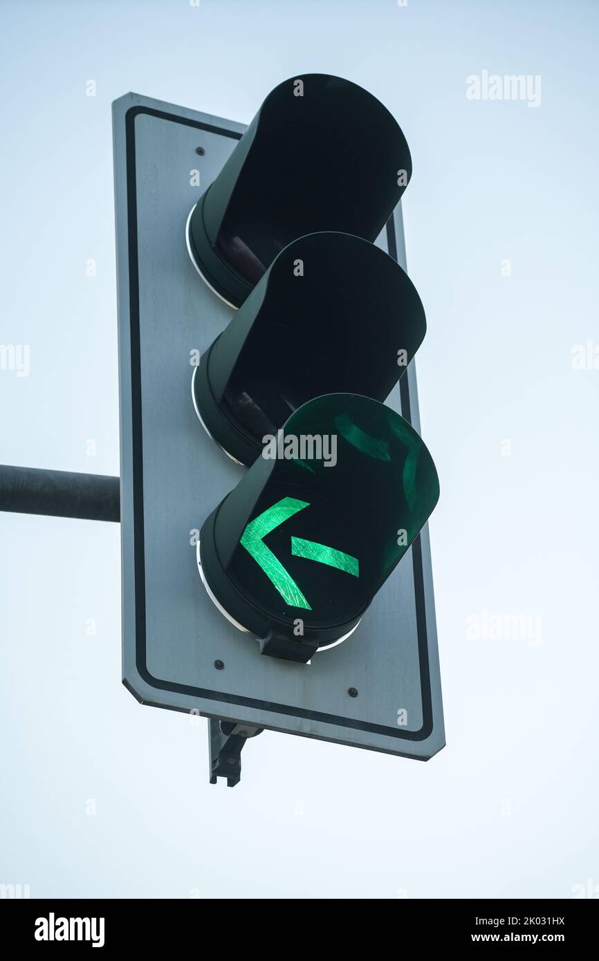 A closeup shot of a traffic light with turn left light on Stock Photo