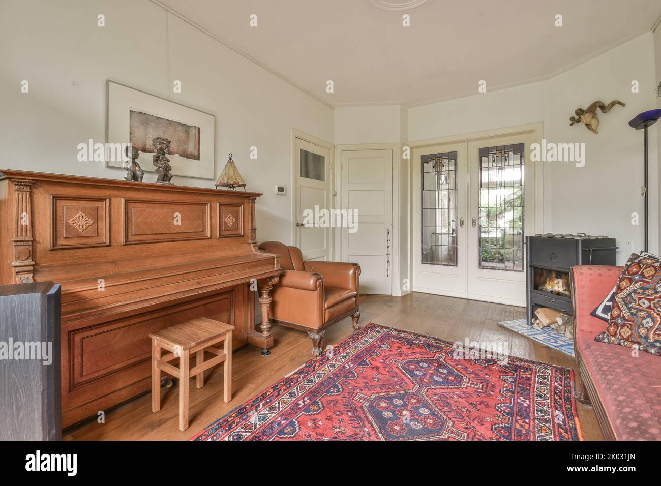 piano and carpet placed in light hall of modern cottage with glass door