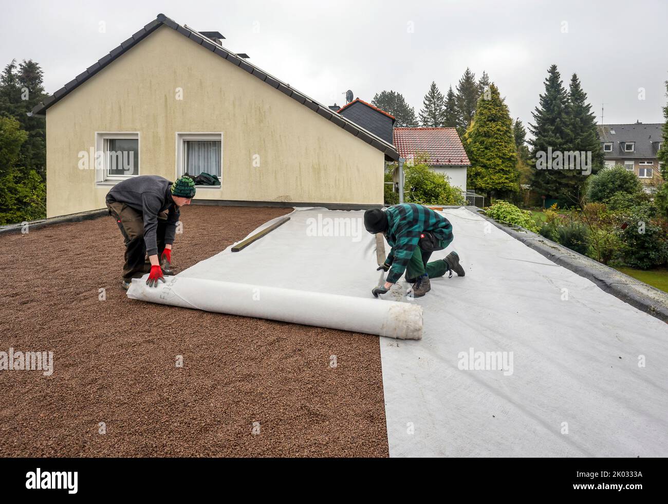 Mülheim an der Ruhr, North Rhine-Westphalia, Germany, flat roof is prepared for green roofing. Here, a separating flow is laid on top of the first fill, the drainage layer. This is then followed by the substrate layer. Stock Photo