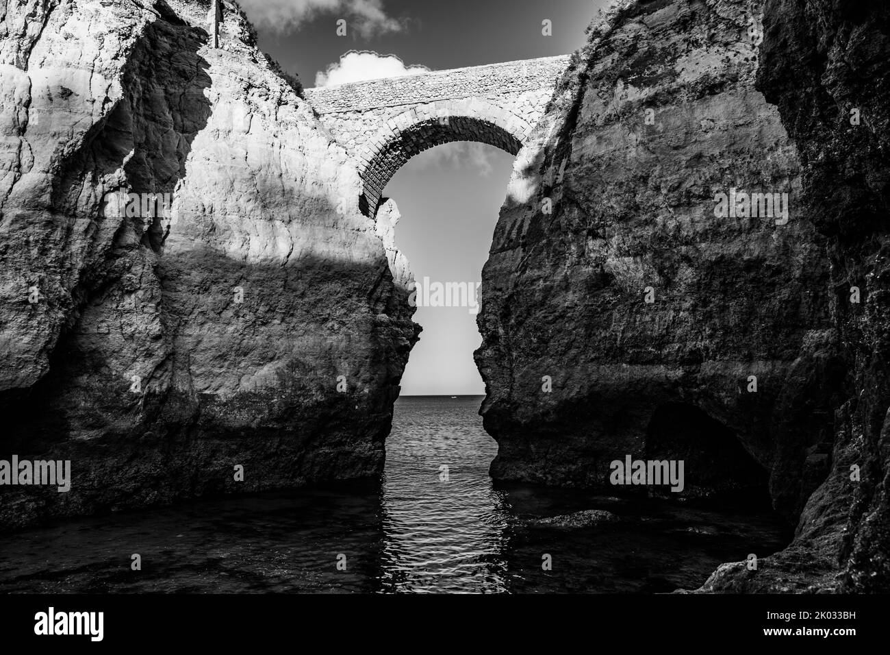 A black of white of the bridge connecting two rocks. Stock Photo