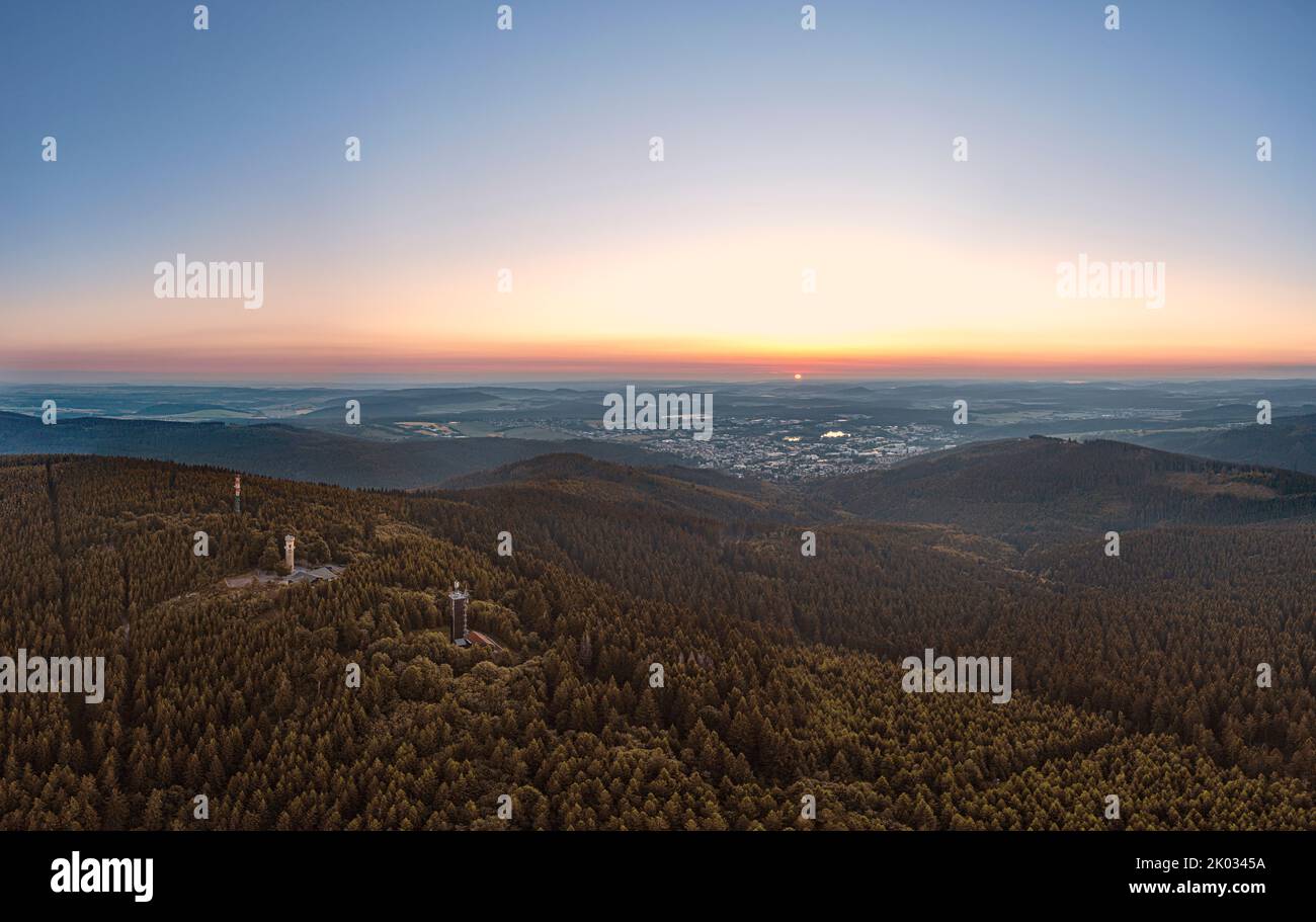 Germany, Thuringia, Ilmenau, Kickelhahn, telecom tower, observation tower, inn, rest area, city (background), forest, mountains, sunrise, backlight, overview, aerial photo Stock Photo