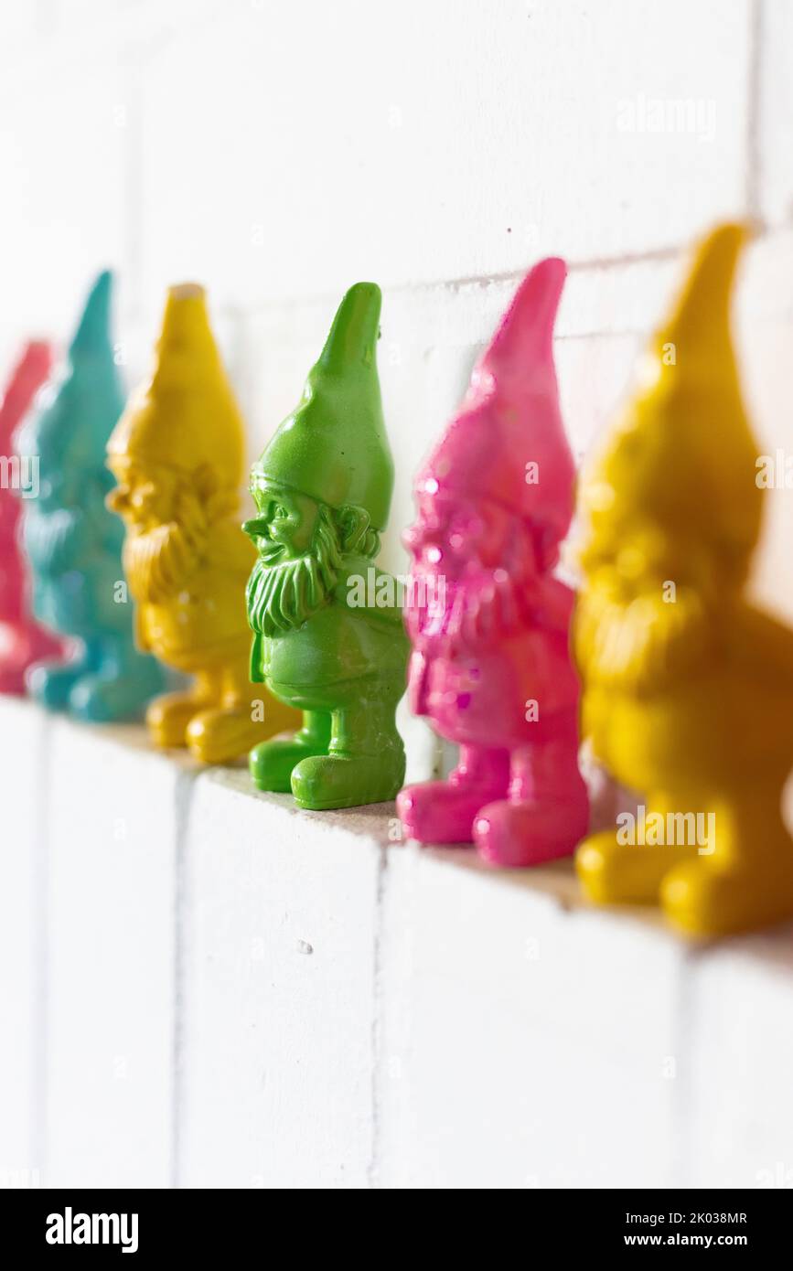 Colorful dwarfs on a white wall Stock Photo