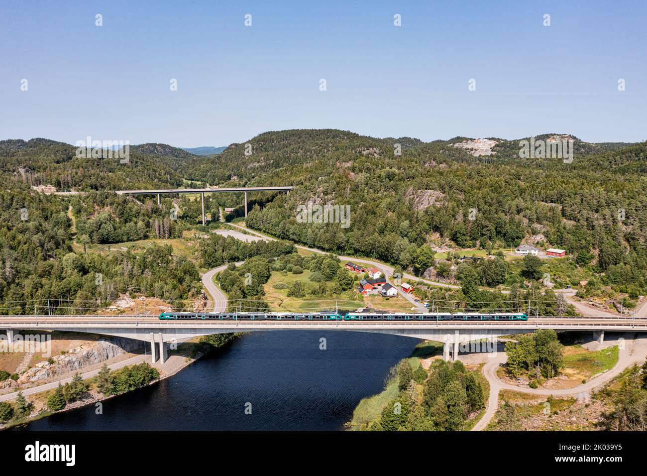 Norway, Vestfold og Telemark, Larvik, Kjose, bridge, train, lake, forest, mountains, highway bridge in background, landscape, overview, aerial view Stock Photo