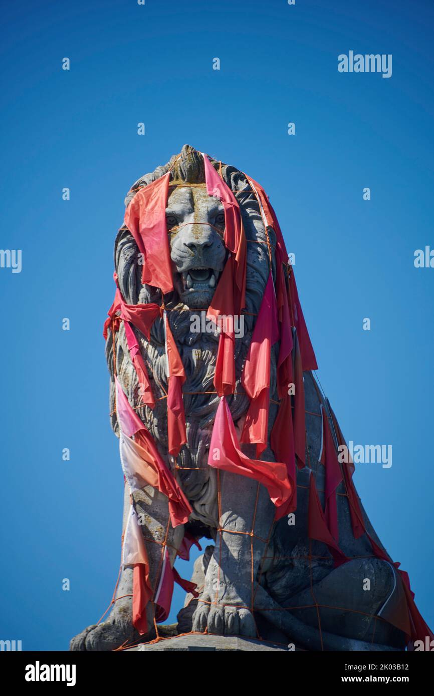 Lion figure with red flags in Lindau at Lake Constance, Bavaria, Germany Stock Photo