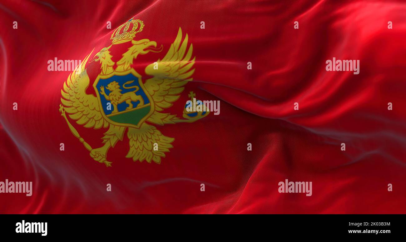 Close-up view of the Montenegro national flag waving in the wind. Montenegro is a country in Southeastern Europe. Fabric textured background. Selectiv Stock Photo