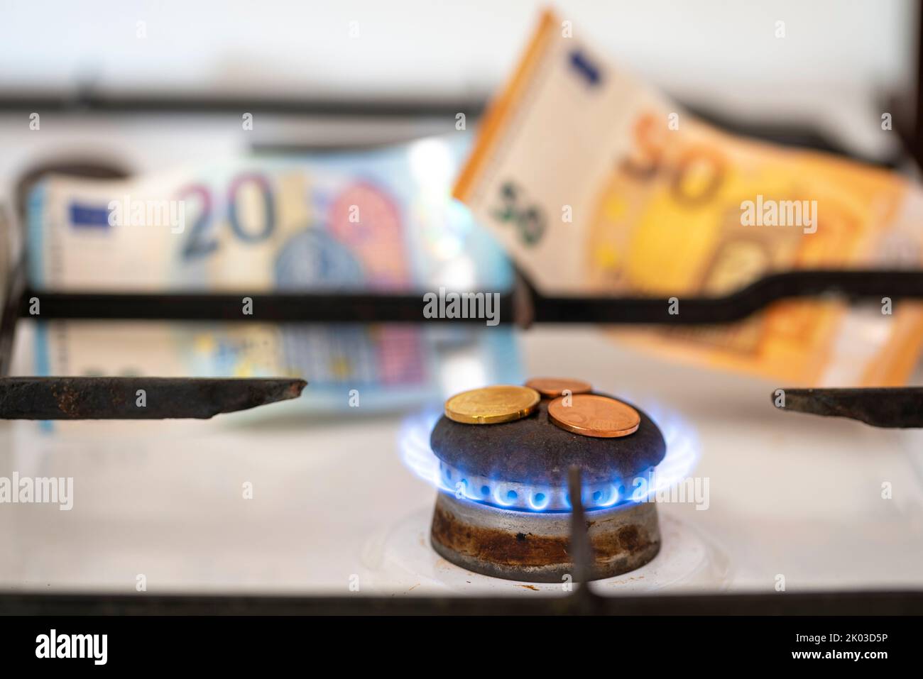 Gas stove hob, gas flame, small change, banknotes behind it Stock Photo ...