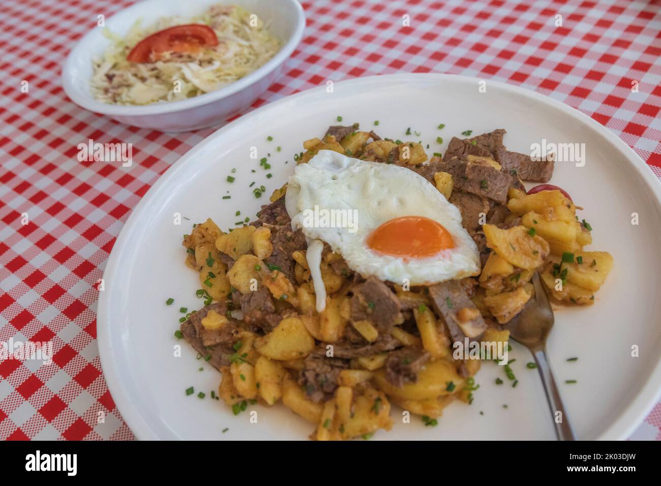 Traditional Tiroler Gröst served with cabbage salad and fried eggs Stock Photo