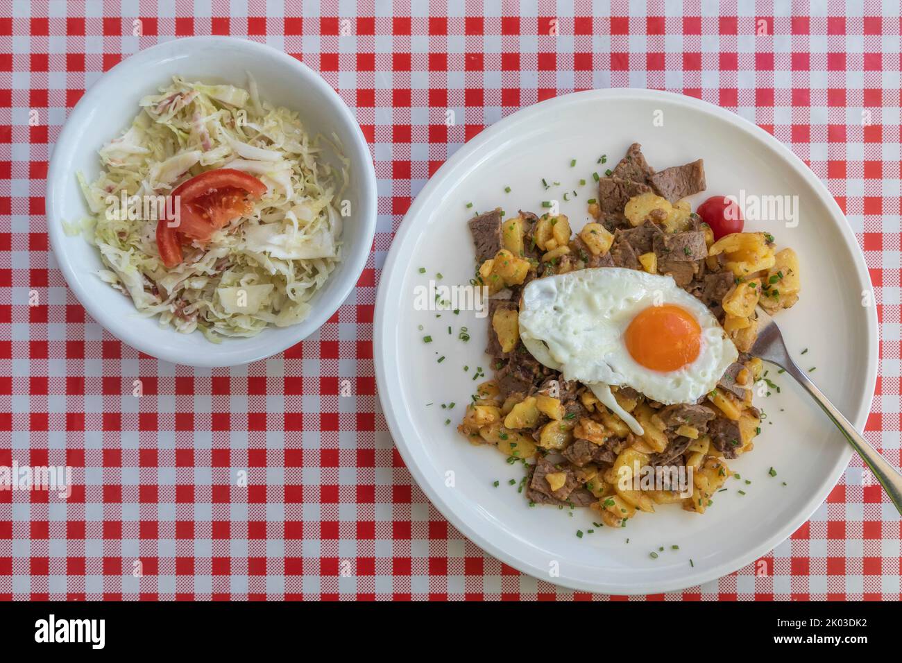 Traditional Tiroler Gröst served with cabbage salad and fried eggs Stock Photo
