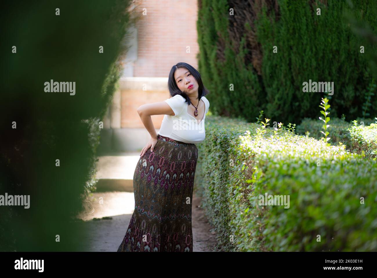 young happy and beautiful Asian Korean woman posing outdoors happy and cheerful at city park pregnant showing her belly proud smiling in pregnancy and Stock Photo