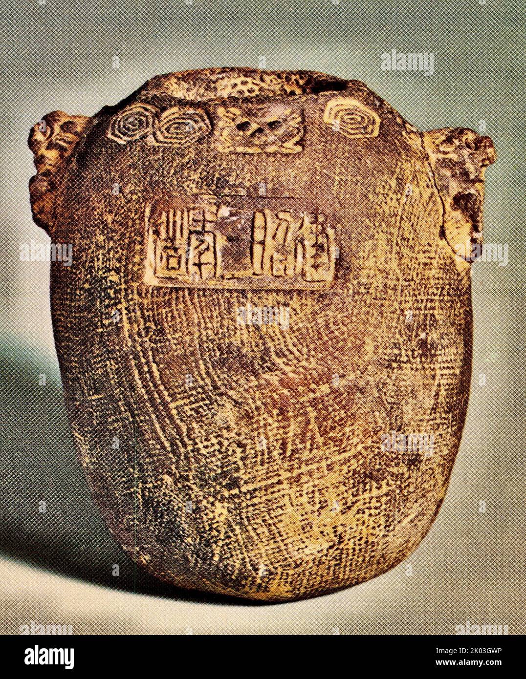 Han Dynasty jar with fine chequered patterns, the mouth is flat, the rim is decorated with cloud and thunder patterns, the middle is decorated with a ring, and the shoulders are decorated with two convex carved beasts. The belly side of the jar is decorated with figures in relief, the opposite side is inscribed with the characters 'Made in the third year of Chien Chao (36 BCE)'. The bottom is smooth, the soil is dark, and the body is covered with loess. The shape is exquisite and simple and elegant. Stock Photo