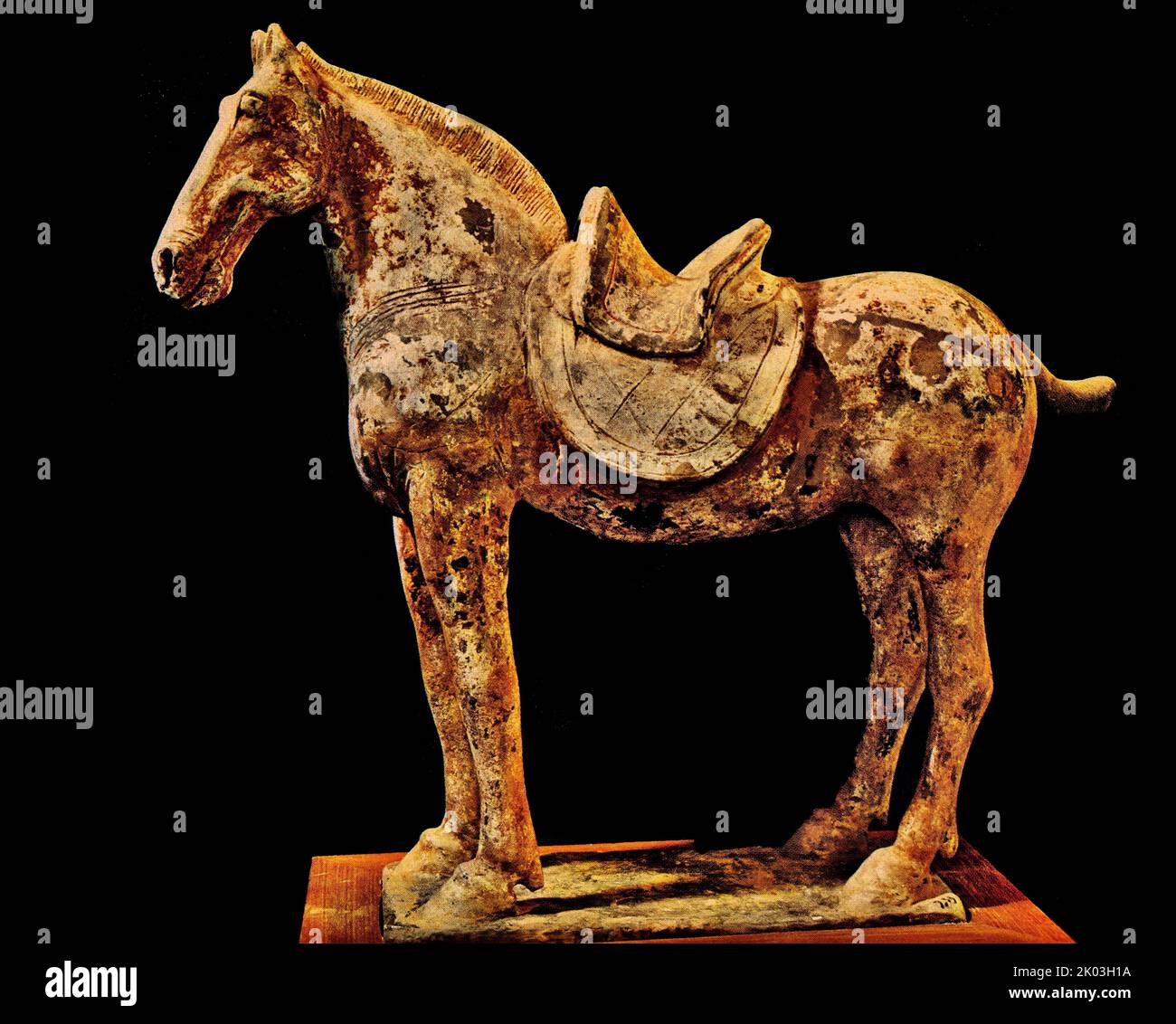 Northern Wei Dynasty figurine of a horse standing, stocky neck, proportionately large ears, small body, long and slim legs, and twisted tail. The saddle gear and body are incised with lines for decoration to render a realistic appearance. The red pigments and white coat have faded and chipped away, other colours spot the surface due to chemical reactions. Stock Photo