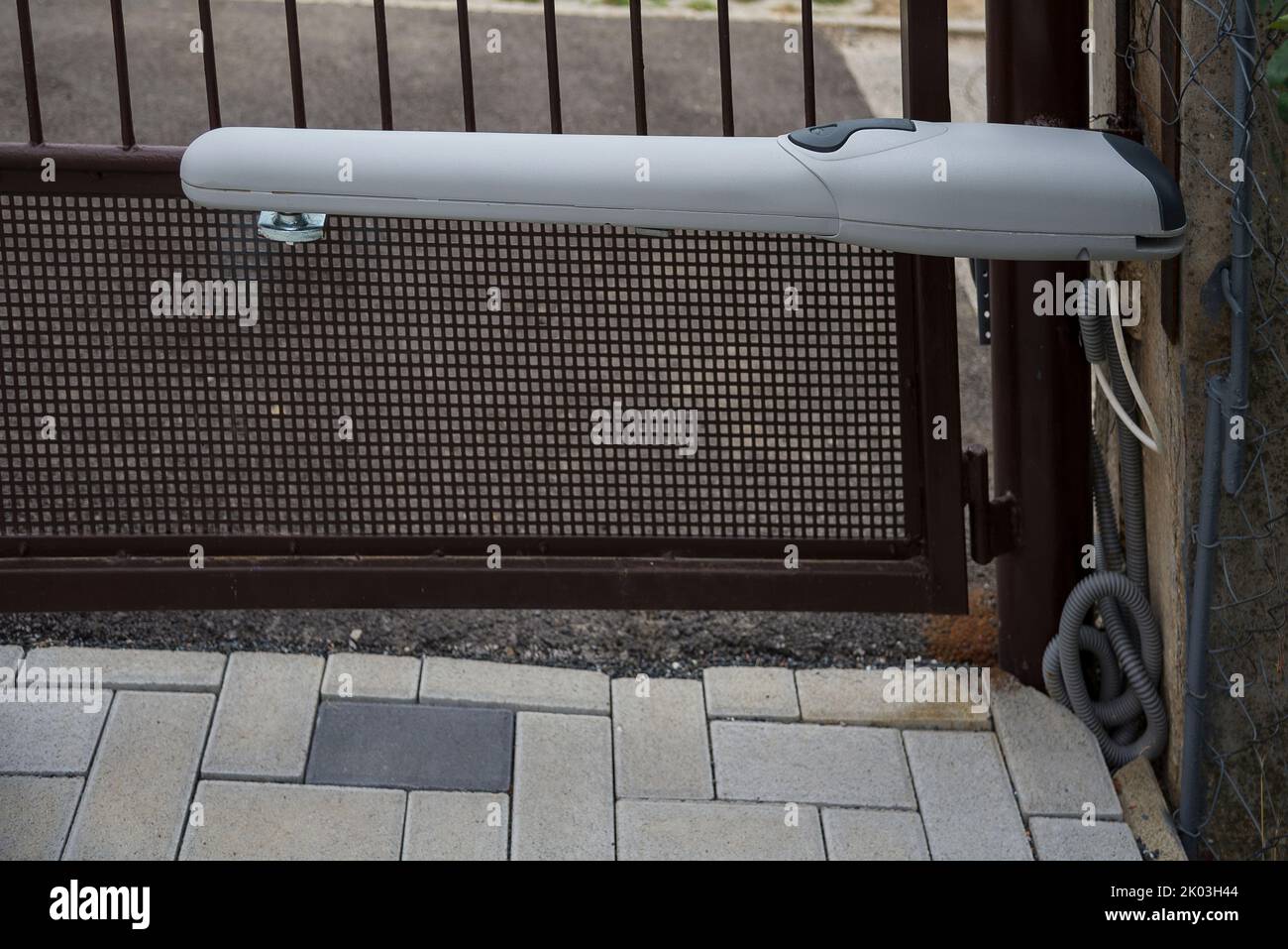 Arm swing electric opener on a older metal gate Stock Photo Alamy