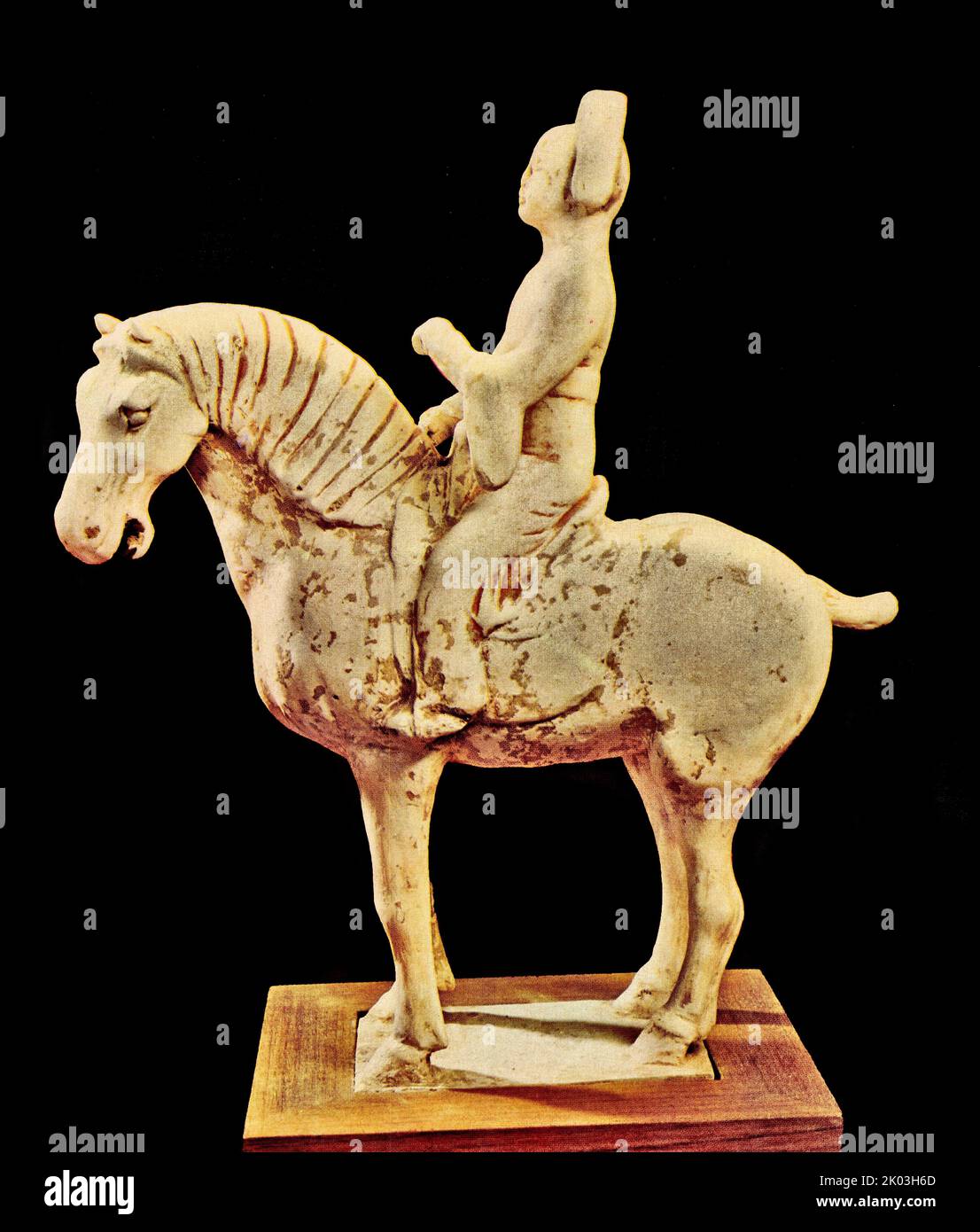 Tang Dynasty horse. white figurine, on an empty stomach, standing upright on a rectangular platform, with a strong horse shape, beige glaze all over the body, slightly light green. Although the horse is standing still, everything from its energetic face, strong legs and bones and strong bones and bones is vigorous and vivid, and the proportions of the shape and application are exquisite. Stock Photo