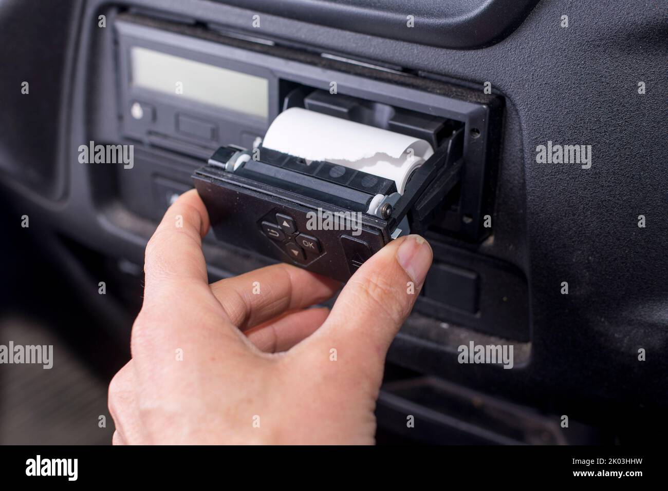 Digital tachograph with an open printer and visible roll of paper