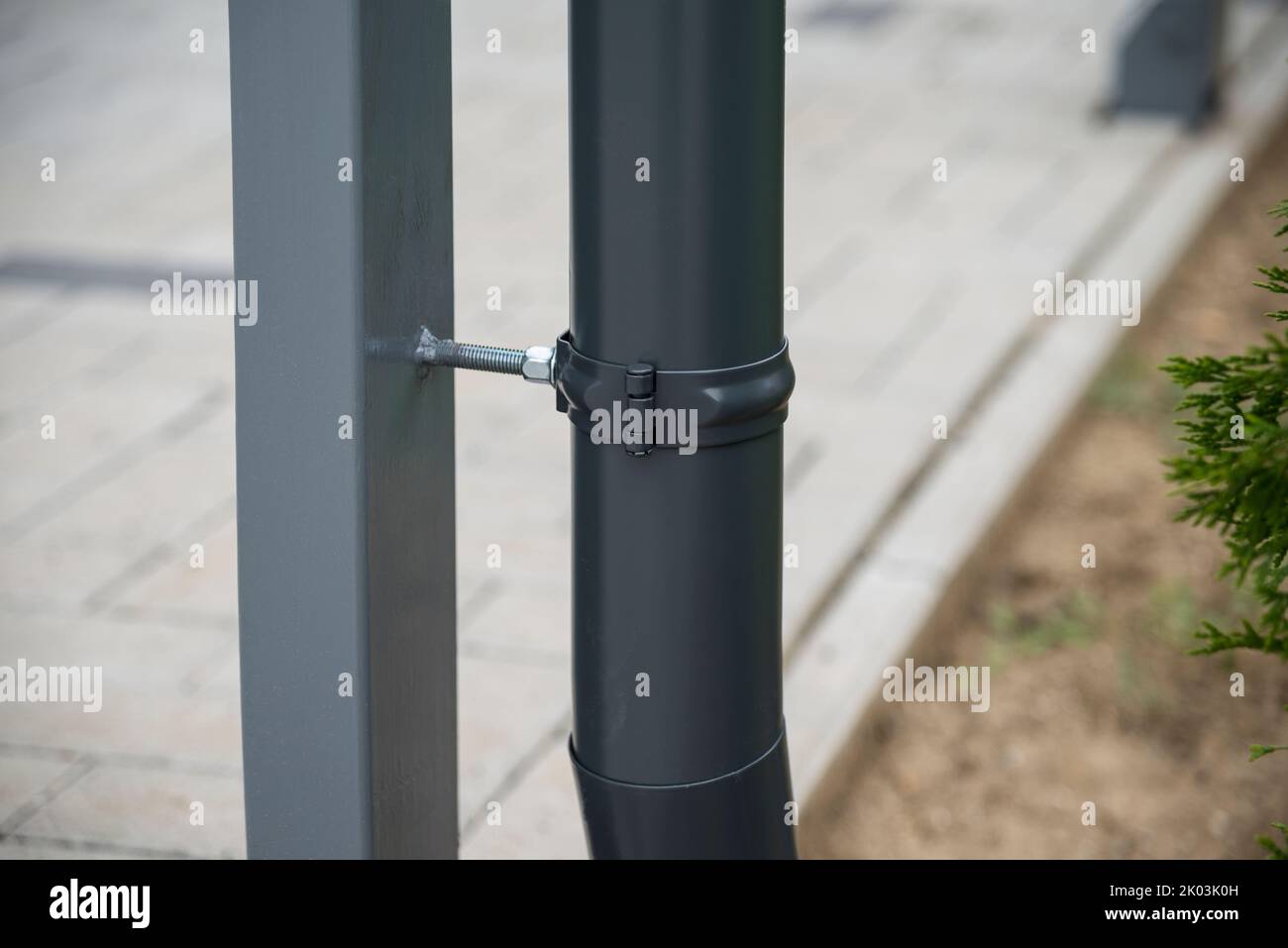 Downspout bracket and pipe welded on a post Stock Photo Alamy