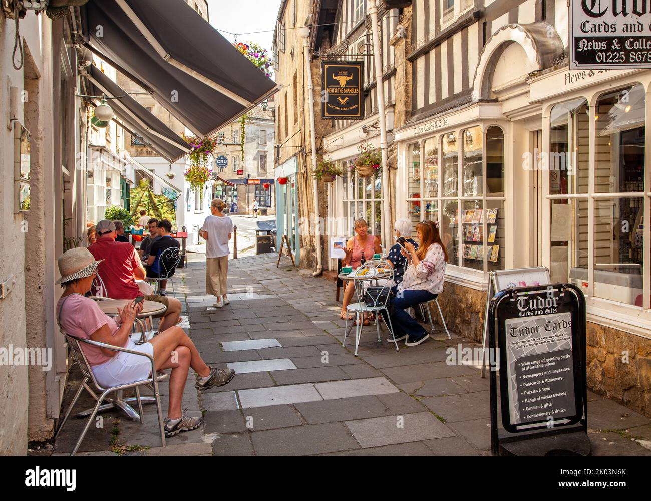 People sitting eating and drinking at cafes in the Shambles in the Wiltshire market town of Bradford on Avon Stock Photo