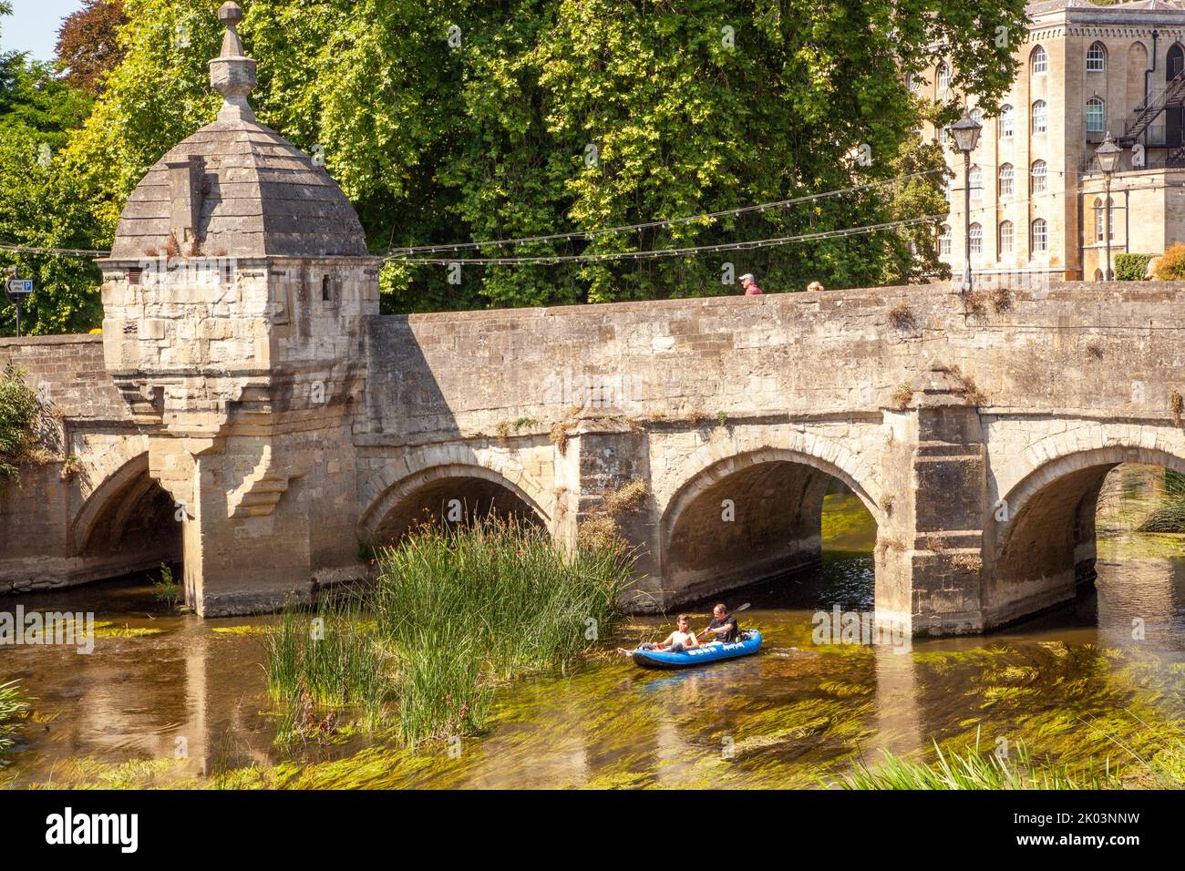 Children in a canoe Kayak on the river Avon passing under the old town bridge in the Wiltshire market town of Bradford on Avon  Wiltshire England Stock Photo