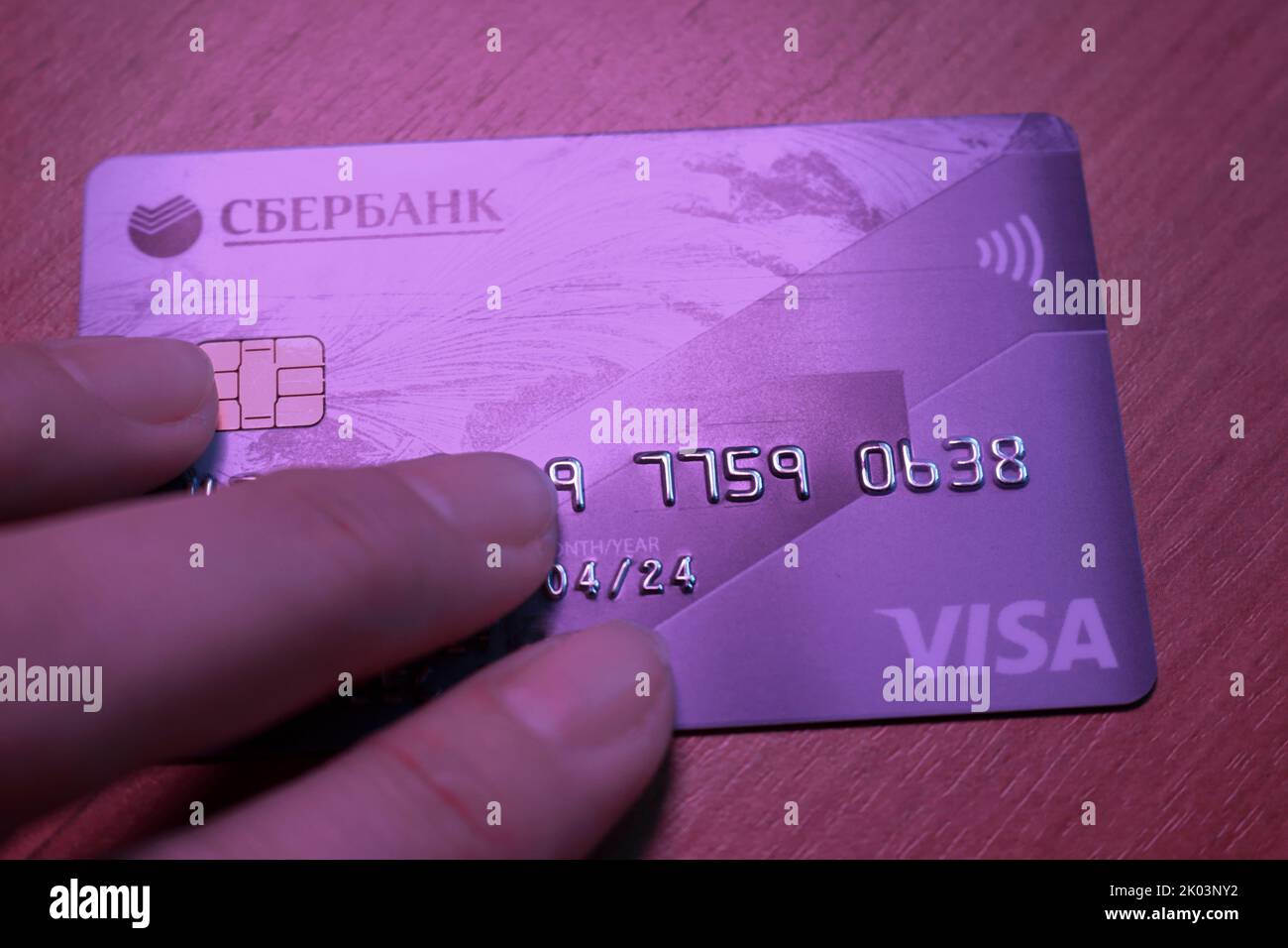 The credit card of Sberbank, which fell under the sanctions, is in hand. Logos Visa, Sberbank close-up. Economic crisis, banking collapse in Russia. M Stock Photo