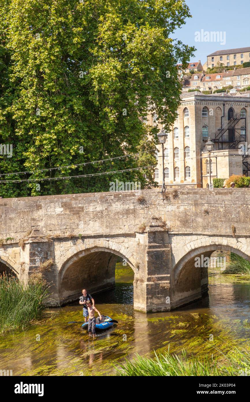 Children in a canoe Kayak on the river Avon passing under the old town bridge in the Wiltshire market town of Bradford on Avon  Wiltshire England Stock Photo